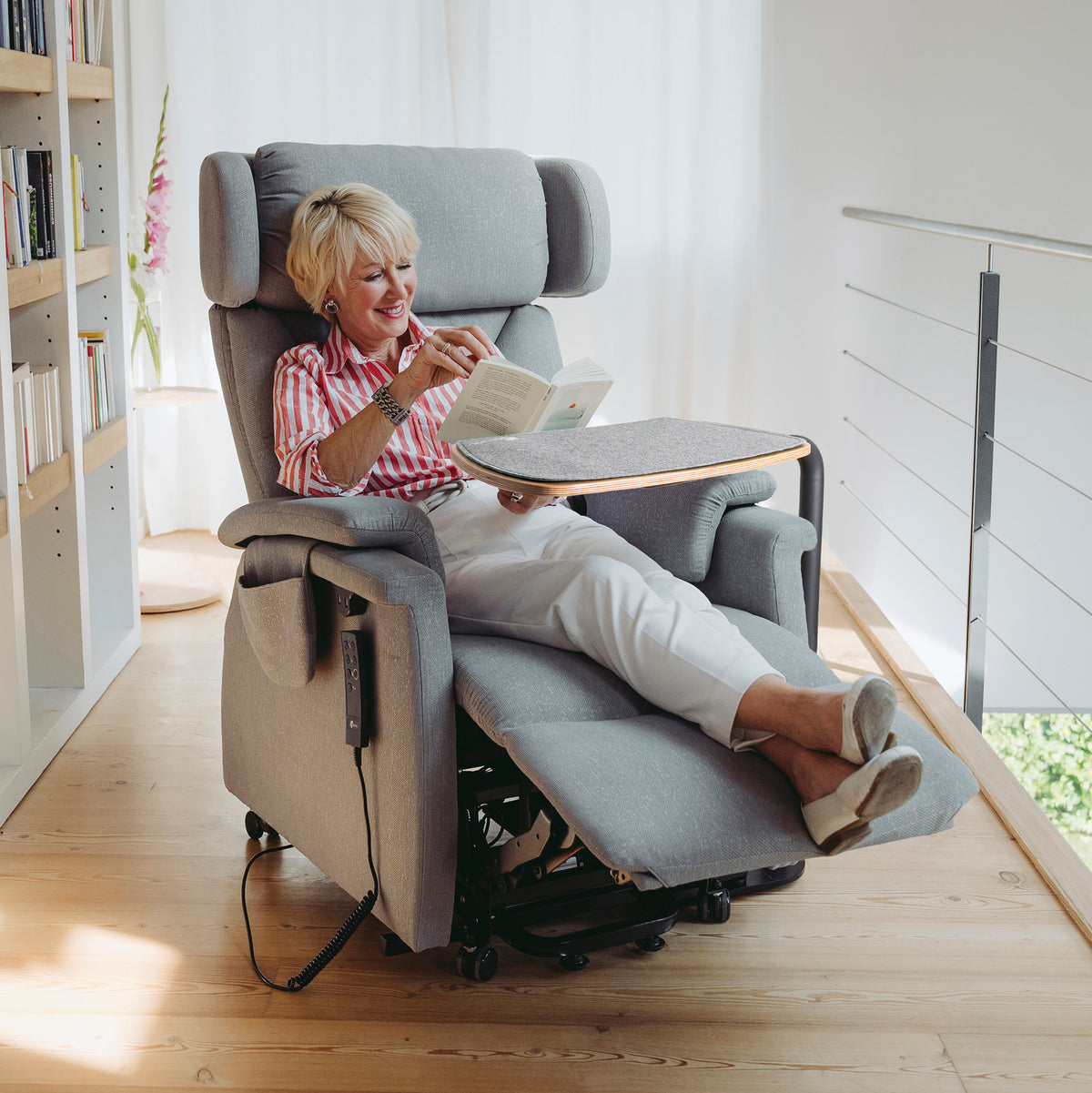 Saljol swivel table for relaxing and stand-up chair, mounted on the left of the chair, woman reading a book in a comfortable position